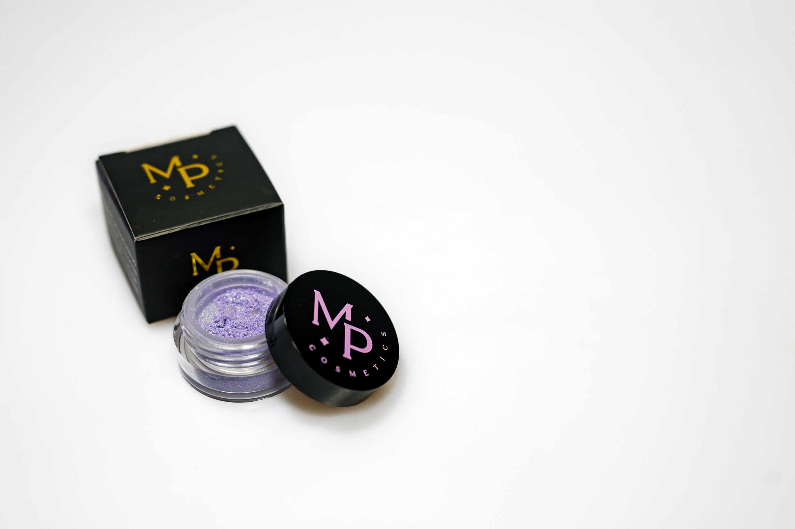 Lauvärv Lillepidu Lilla mineraalne pulber lauvärv musta kaanega potsikus ning kõrval must logoga tootekarbike.