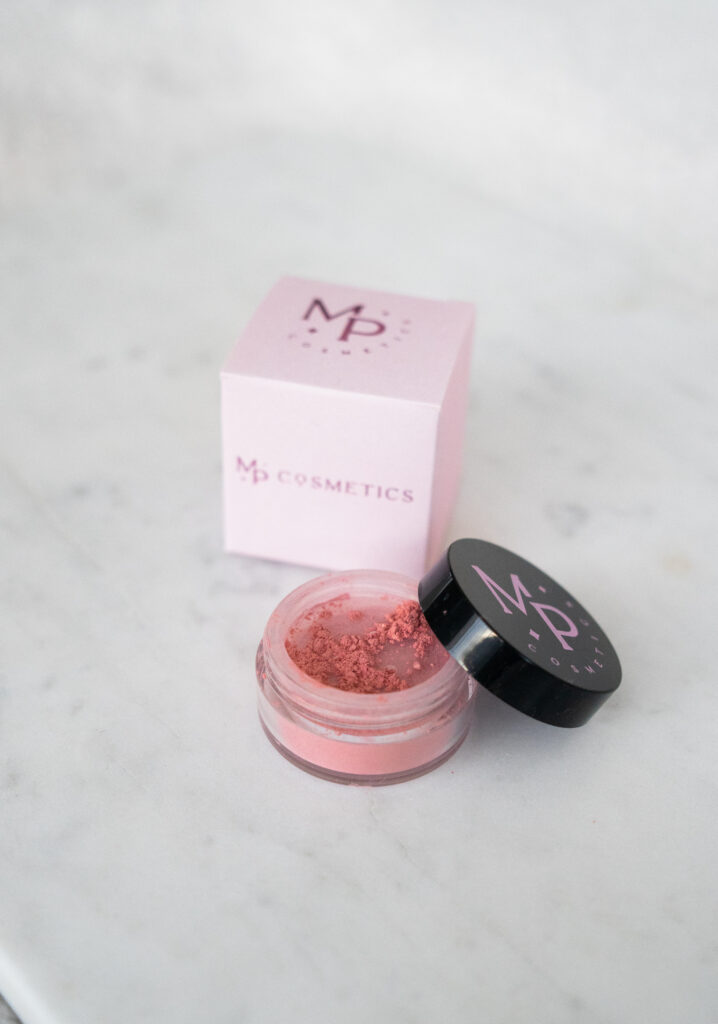 Roosa mineraalne põsepuna toonis "Printsessipale" musta kaanega potsikus ja roosa karp.